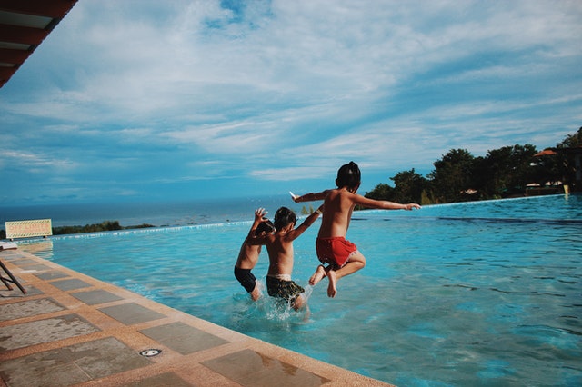 children having fun jumping into pool
